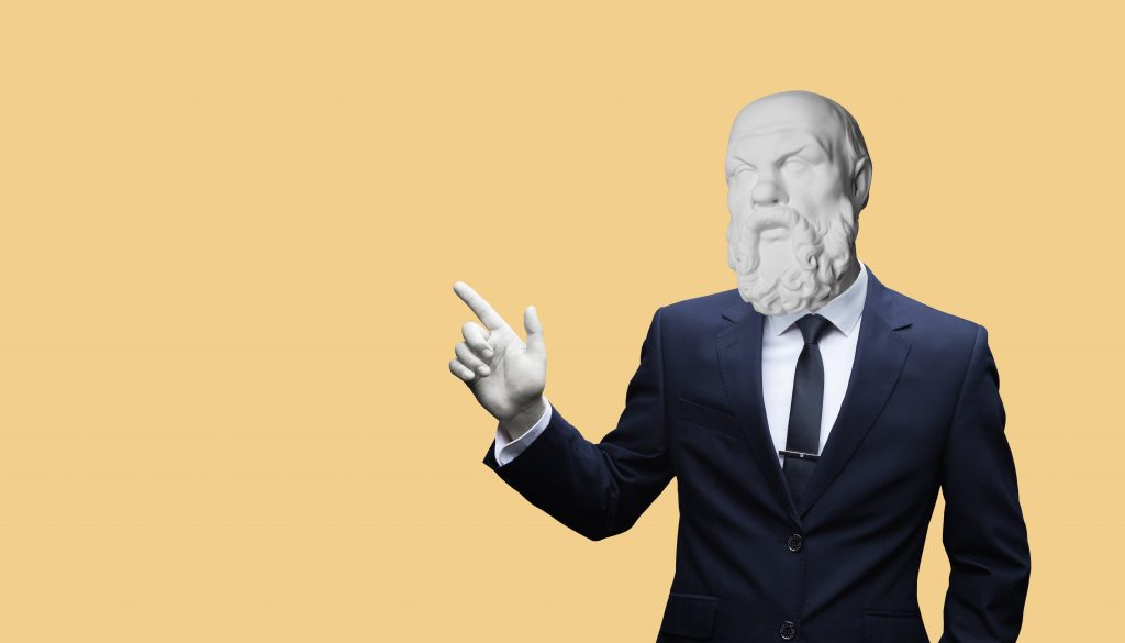 Sokrates im Business-Anzug zeigt auf die Gedanken von Joined Learning.